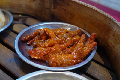 Chicken feet dimsum served on tin bowl on the wooden steam bowl. close up