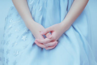 Girl's hands against a blue background