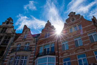 Low angle view of buildings against sky on sunny day