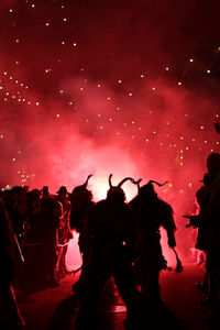 Silhouette people watching firework display at night