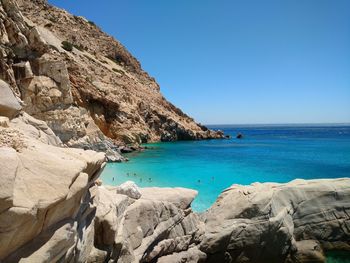 Scenic view of sea and rock formations against clear sky