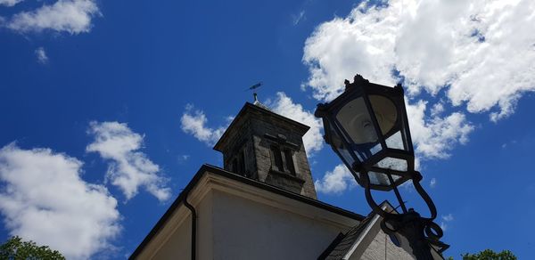 Low angle view of building and street light against blue sky