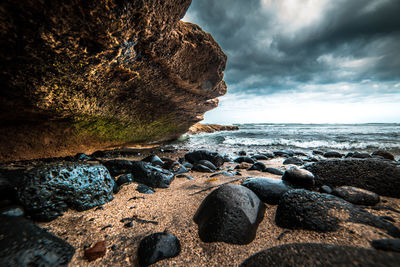 Close-up of rocks in sea against sky