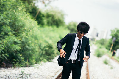 Businessman walking on railroad track