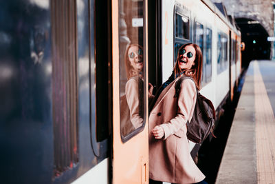 Portrait of happy woman standing in train