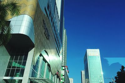 Low angle view of modern buildings against clear blue sky