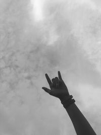 Low angle view of person hand against sky