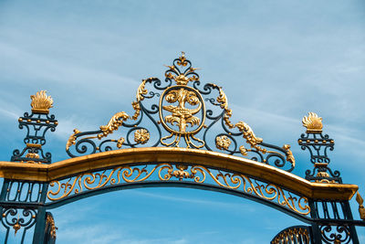 Low angle view of ornate gate against sky