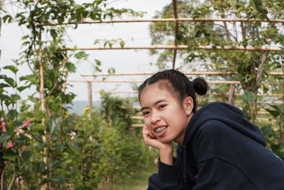 Portrait of smiling woman against plants