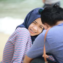 Smiling young woman talking with man outdoors