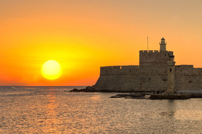 Scenic view of sea against orange sky