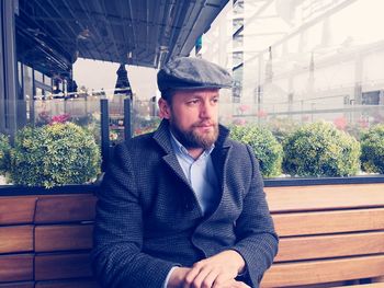 Man looking away while sitting on bench