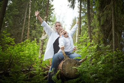 Rear view of woman standing in forest