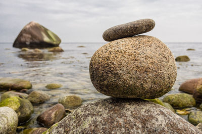 Close-up of stones on beach against sky