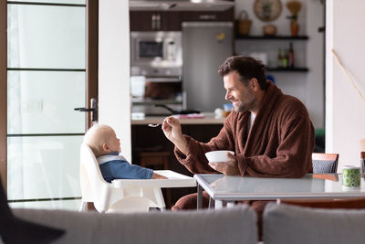 Side view of woman using mobile phone at home