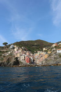 Houses by sea against sky in town