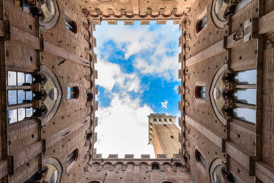 Directly below view of palazzo pubblico against sky