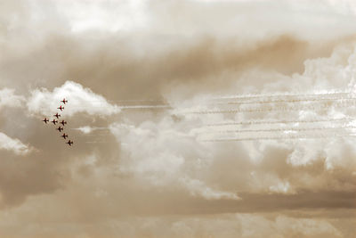 Low angle view of airshow against vapor trail in sky