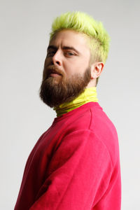 Portrait of young man standing against white background