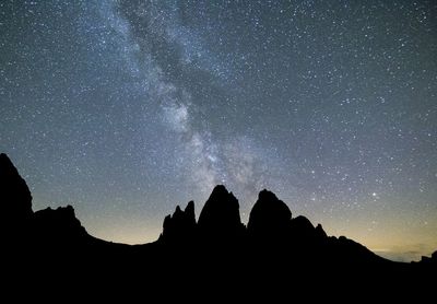 Low angle view of silhouette trees against sky at night