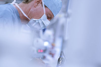 Neurosurgeon in scrubs looking down