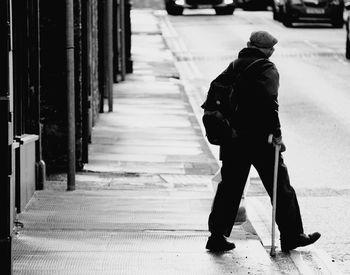 Rear view of man walking on street in city