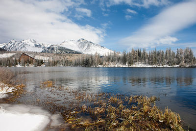 Scenic view of frozen lake by snowcapped mountains against sky
