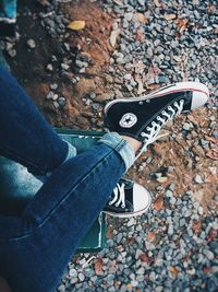 Low section of woman standing on pebbles