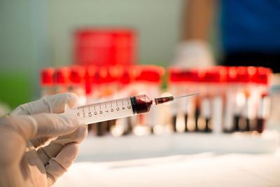 Cropped hand of doctor holding syringe at hospital