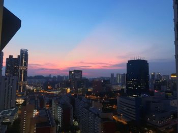 Illuminated buildings against sky during sunset