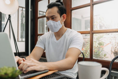 Man using mobile phone while sitting on table