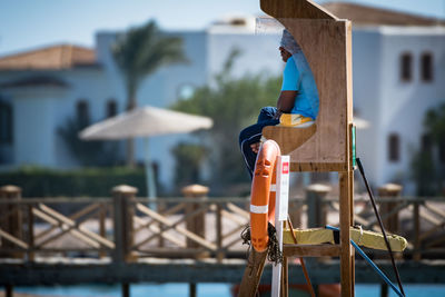 Close-up of lifeguard sitting on beach