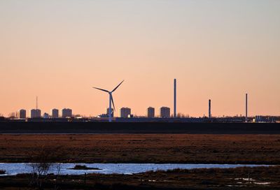 Scenic view of sea against sky during sunset. windfarm in the background.