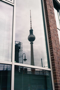 Low angle view of communications tower in city