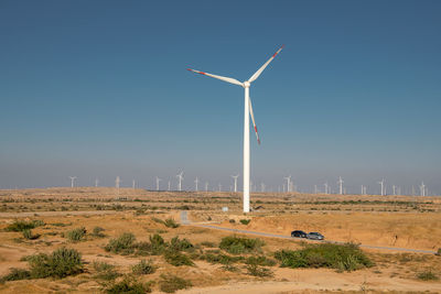 Windmill on field against clear sky