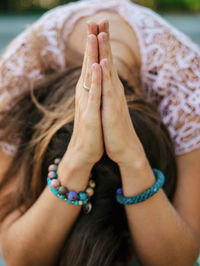 Close-up of young woman with hands clasped