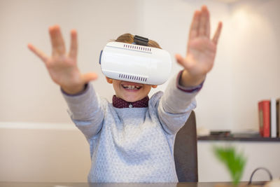 Cute boy wearing virtual reality simulator at home