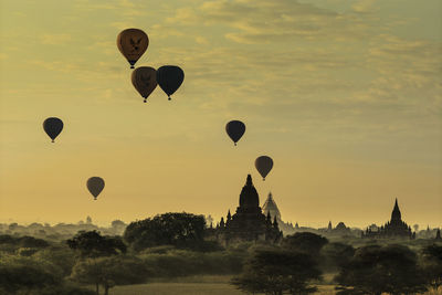Silhouette of hot air balloons against sky during sunset
