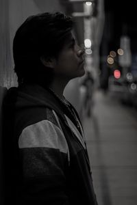 Portrait of young woman looking away at night