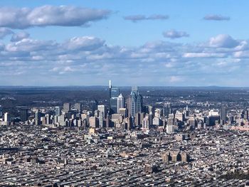 Aerial view of buildings against cloudy sky