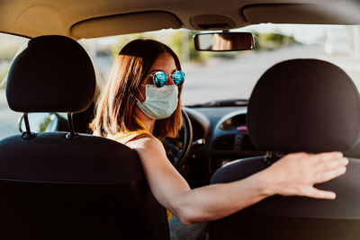 Rear view of woman sitting in car