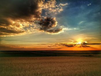 Scenic view of field against sky at sunset