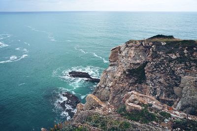 Rock formations by sea against sky