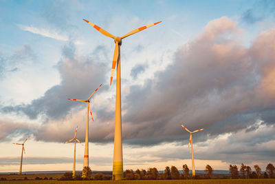 Low angle view of windmill on field against sky