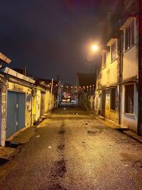 Street amidst buildings against sky at night