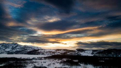 Scenic view of snowcapped mountains against sky during sunset