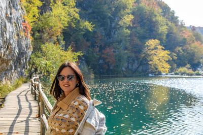Young woman in plitvice lakes national park in croatia on a sunny day in autumn.
