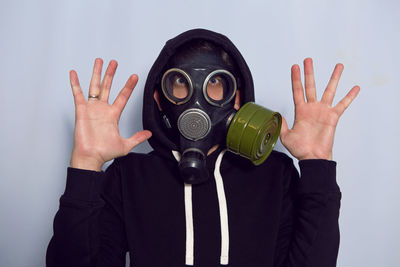 Man in a black gas mask stands against a white wall during a coronavirus epidemic