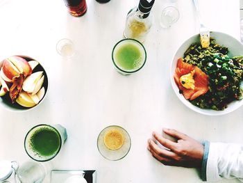 Cropped image of hand with food and drink on table