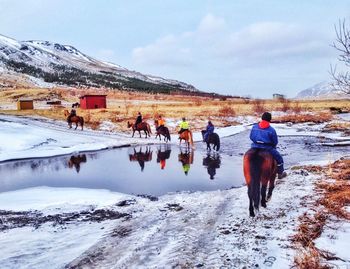 Tourists walking on snow covered mountain